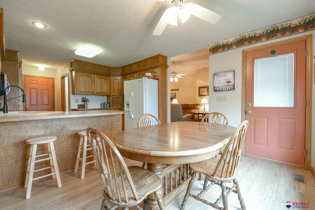 dining room with visible vents, a ceiling fan, and light wood-style flooring