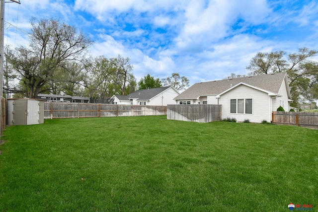view of yard with a storage unit, a fenced backyard, and an outdoor structure
