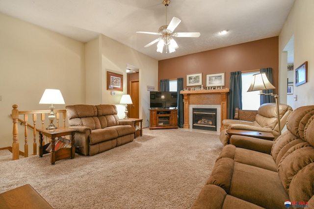 living area featuring ceiling fan, light carpet, and a fireplace