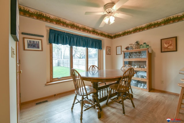 dining space featuring visible vents, light wood finished floors, ceiling fan, and baseboards
