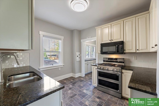 kitchen featuring black microwave, plenty of natural light, double oven range, and a sink