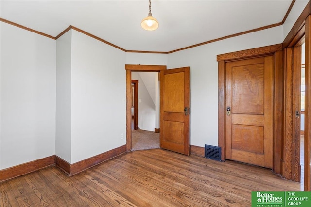 interior space with crown molding, baseboards, and wood finished floors