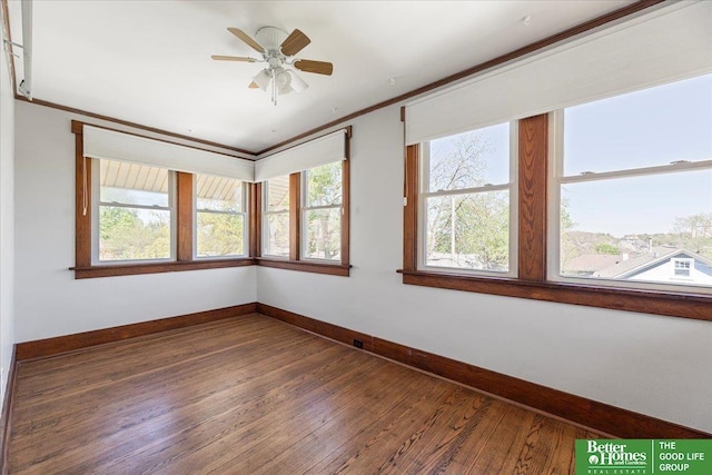 empty room with baseboards, ornamental molding, and hardwood / wood-style floors