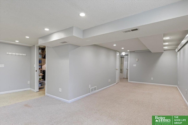 finished below grade area featuring visible vents, carpet flooring, and recessed lighting