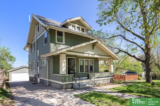 american foursquare style home featuring fence, a detached garage, a porch, a front yard, and an outdoor structure
