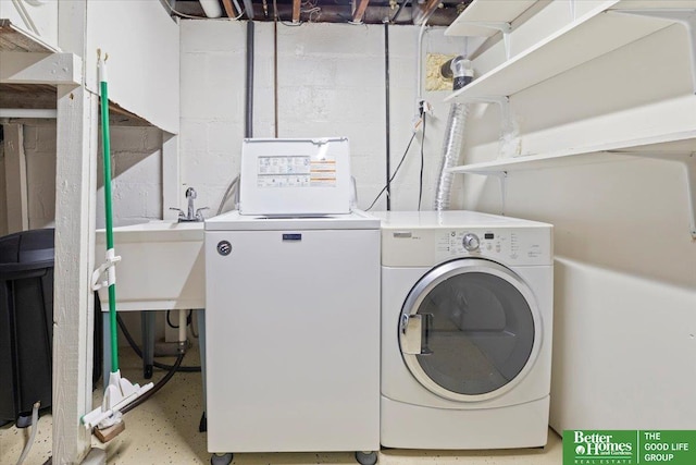 laundry area with separate washer and dryer, laundry area, and concrete block wall