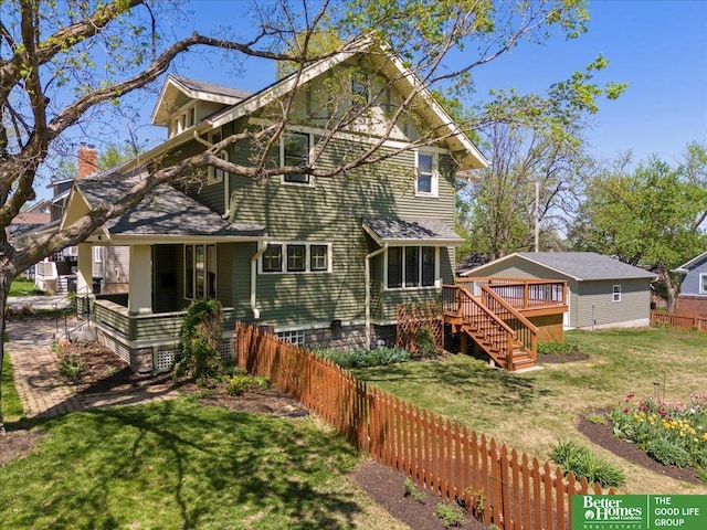rear view of property with a lawn, fence, stairway, and a deck