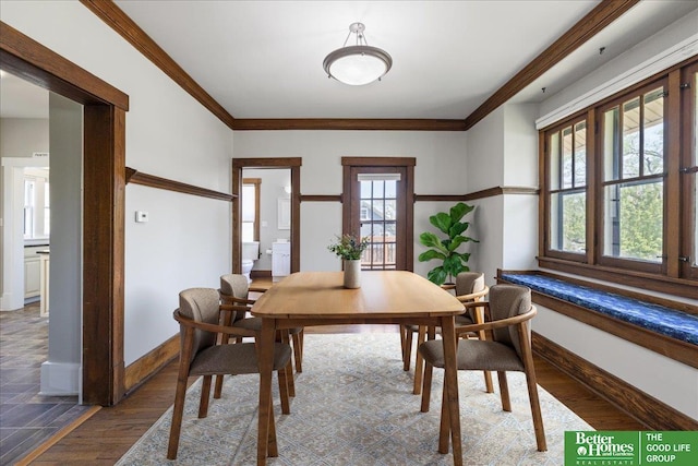 dining area with crown molding, baseboards, and wood finished floors