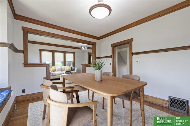 dining area featuring baseboards, dark wood finished floors, and ornamental molding