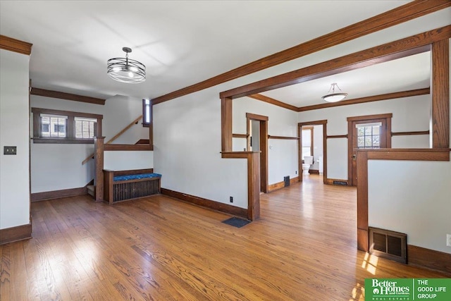interior space with visible vents, crown molding, wood finished floors, stairway, and baseboards