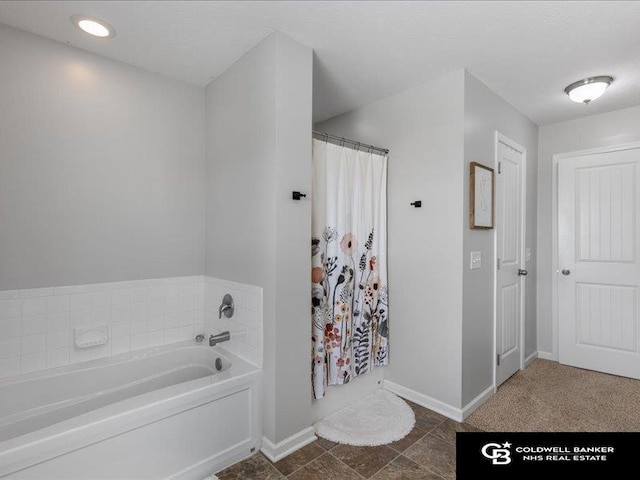 bathroom with baseboards, a shower with curtain, and a bath