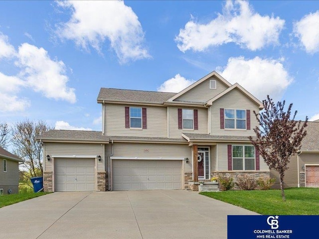 craftsman-style home featuring an attached garage, driveway, and stone siding