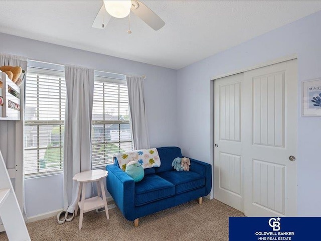 living area with ceiling fan and carpet