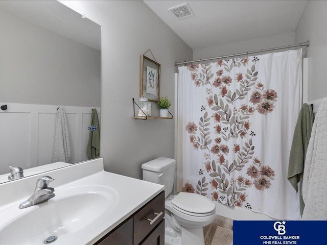 full bathroom with vanity, a shower with curtain, toilet, and visible vents