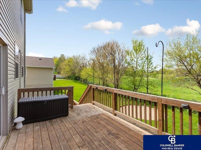 wooden terrace featuring a lawn