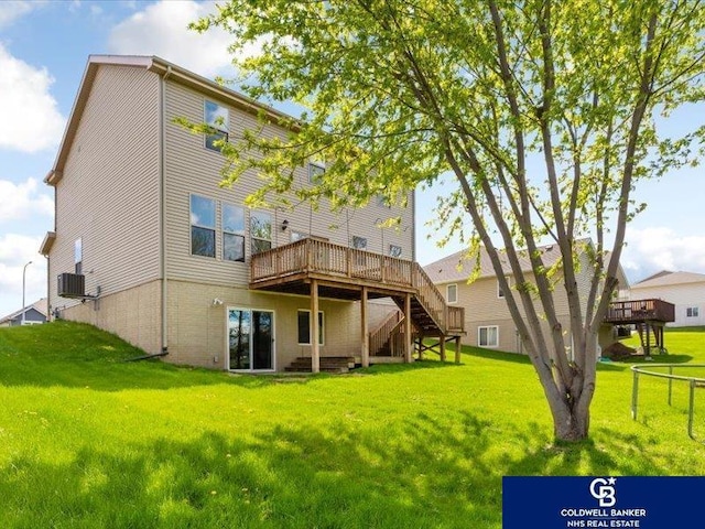 rear view of property featuring a lawn, a deck, and stairway