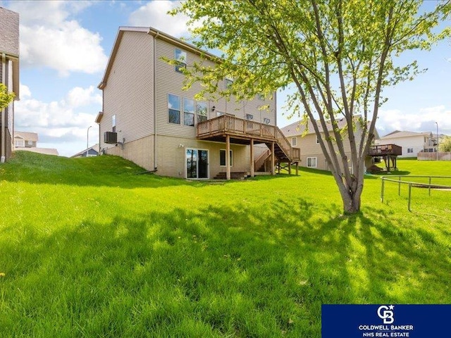 back of property featuring a wooden deck, a yard, central AC, and stairway