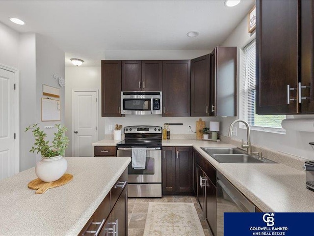 kitchen with dark brown cabinets, a sink, light countertops, stainless steel appliances, and recessed lighting