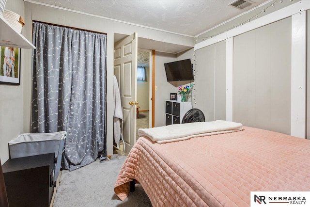 carpeted bedroom featuring crown molding, visible vents, and a closet