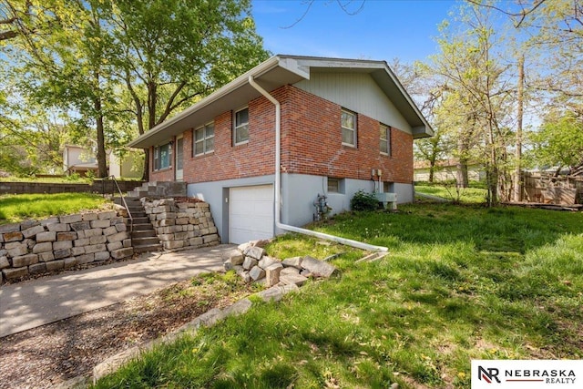 view of home's exterior with a garage, fence, driveway, brick siding, and a yard