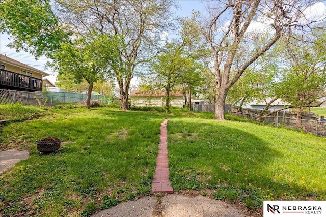 view of yard with fence and a fire pit