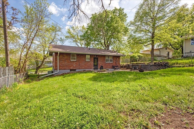 back of property with brick siding, a fenced backyard, a lawn, and a patio