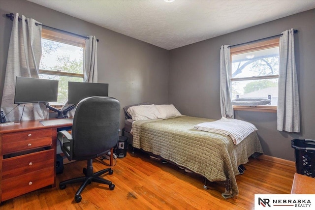 bedroom featuring multiple windows and wood finished floors