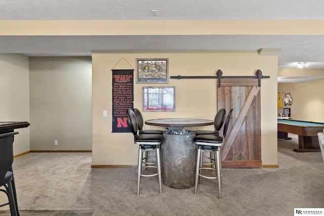 dining room featuring baseboards, carpet, and a barn door