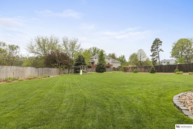 view of yard with a fenced backyard and a playground