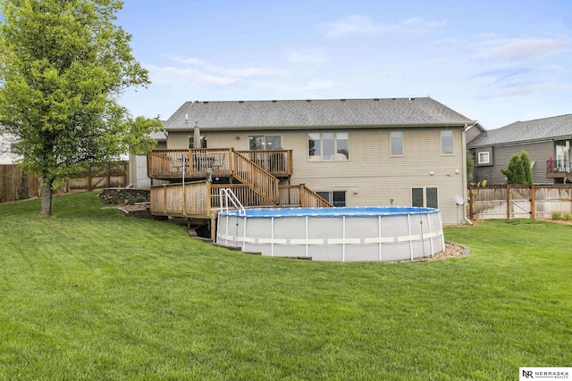 back of property with stairs, a wooden deck, a fenced backyard, a fenced in pool, and a yard