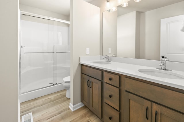 bathroom with visible vents, a sink, wood finished floors, and toilet