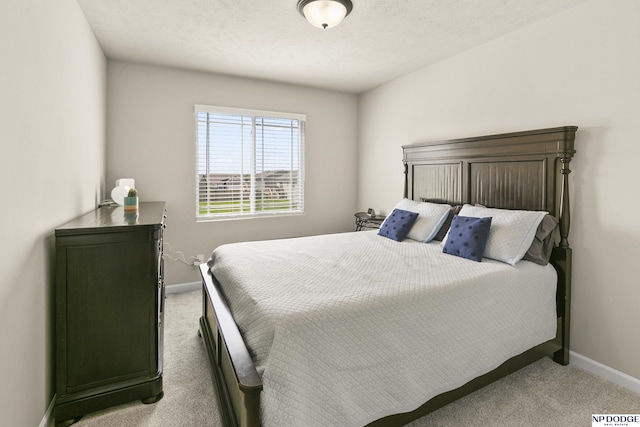 bedroom with baseboards and light carpet