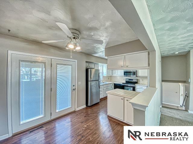 kitchen with light countertops, stainless steel appliances, baseboards, and backsplash