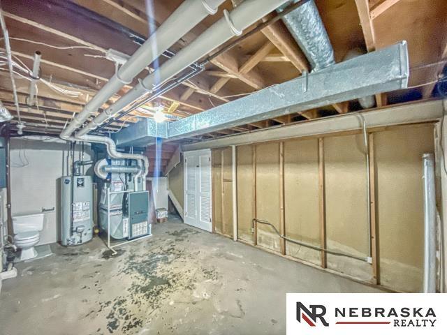 unfinished below grade area with heating unit and water heater