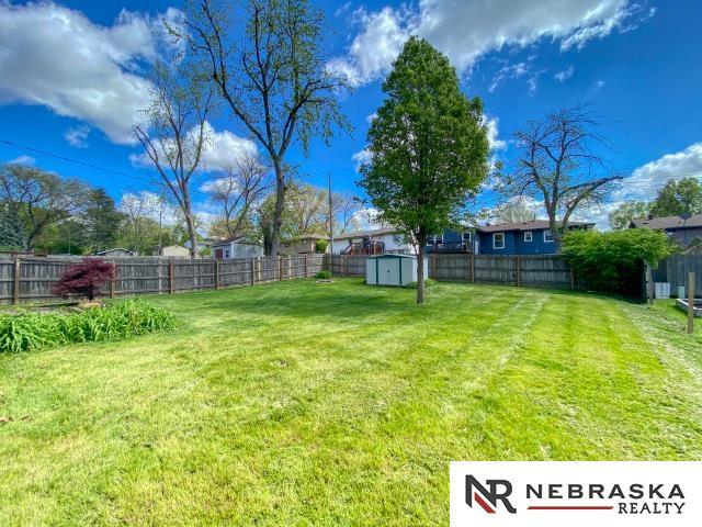 view of yard with a storage shed, an outbuilding, and a fenced backyard