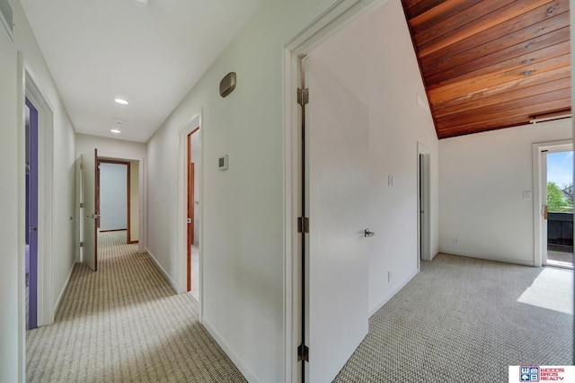 hall featuring recessed lighting, baseboards, light colored carpet, and vaulted ceiling