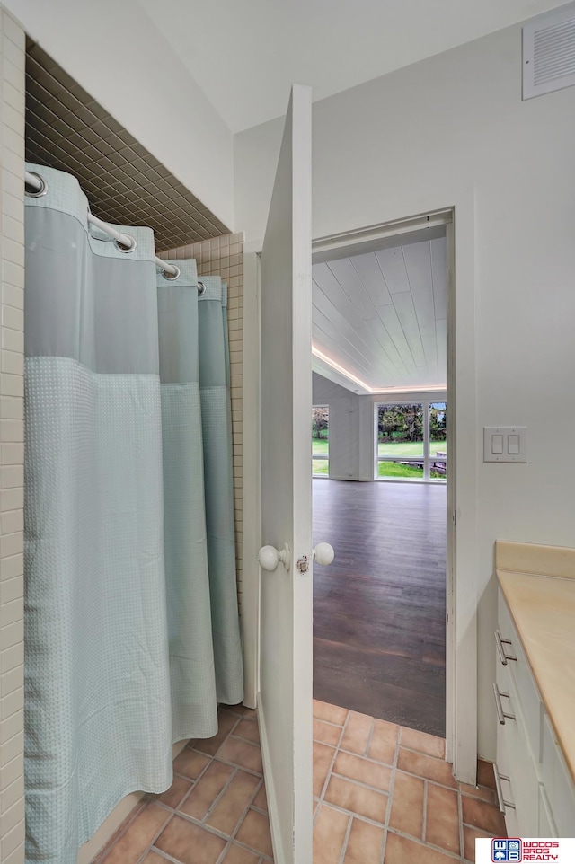 full bathroom featuring vanity, tile patterned flooring, a shower with shower curtain, and visible vents