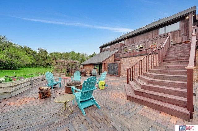 view of patio / terrace featuring stairway and a fire pit