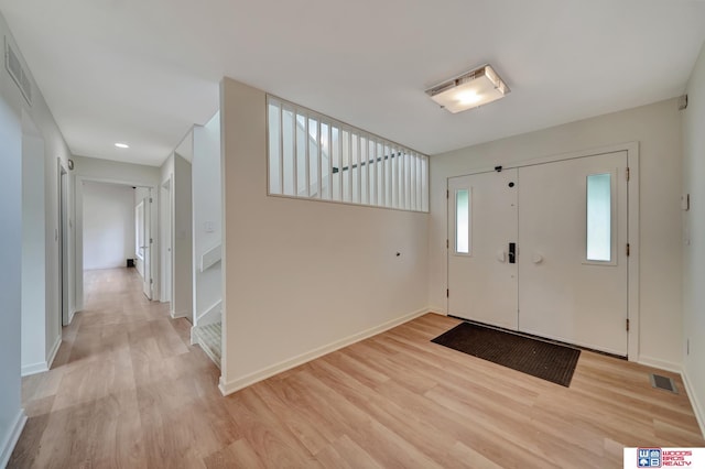 entryway with baseboards, visible vents, and light wood-type flooring