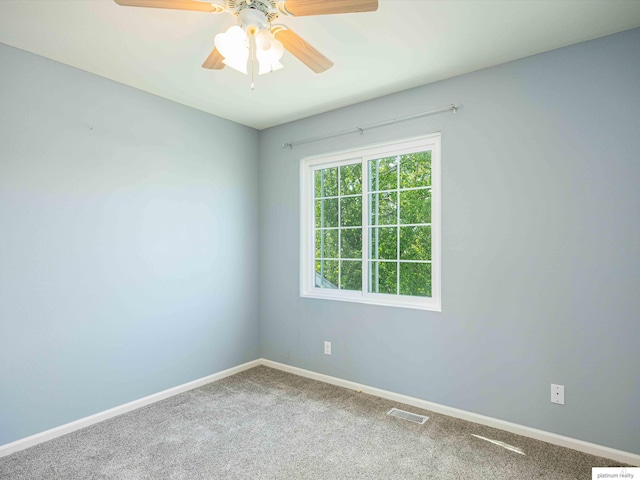 carpeted empty room featuring a ceiling fan and baseboards
