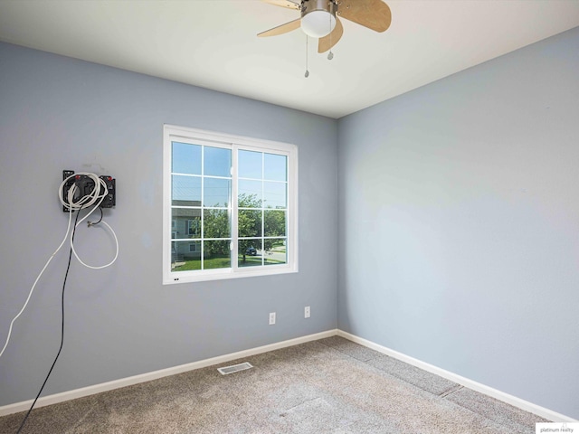 carpeted spare room with baseboards and ceiling fan