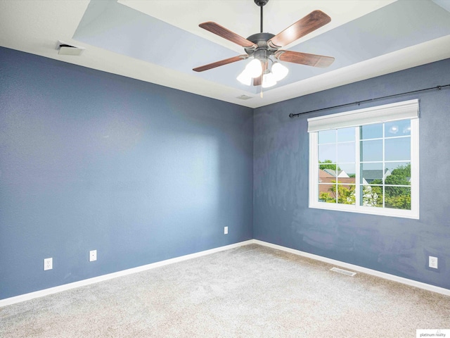 carpeted empty room featuring baseboards and ceiling fan