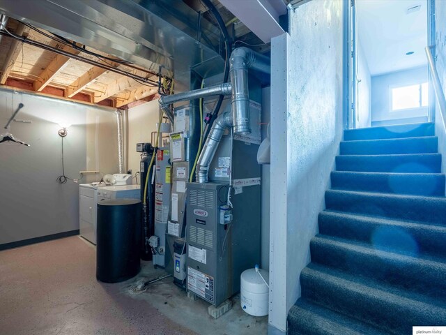 below grade area with separate washer and dryer, stairs, and gas water heater