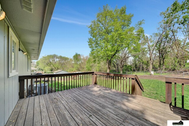 wooden deck with a yard, central air condition unit, and visible vents