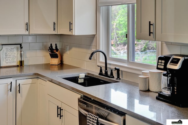 kitchen with a sink, decorative backsplash, dishwasher, and white cabinets