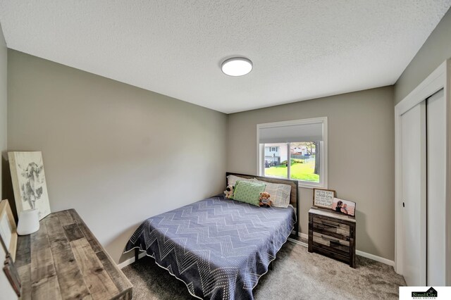 bedroom with carpet floors, baseboards, a closet, and a textured ceiling