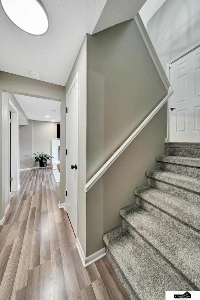 stairway with baseboards and wood finished floors