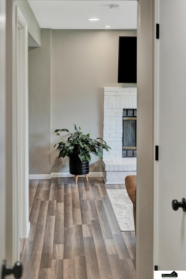 corridor featuring baseboards and wood finished floors