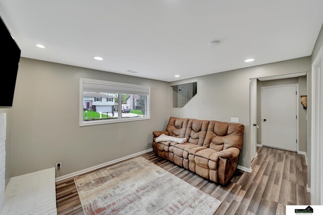 living room featuring baseboards, recessed lighting, and wood finished floors