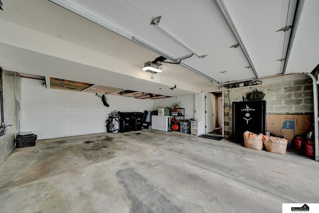 garage with concrete block wall and a garage door opener